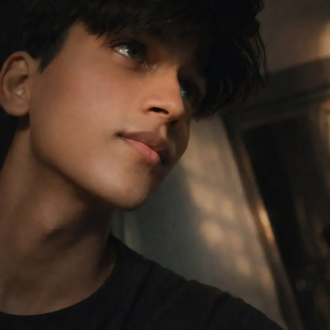 Close-up of Mohammed Hashmi Ansari in warm light, eyes lifted, hair falling forward